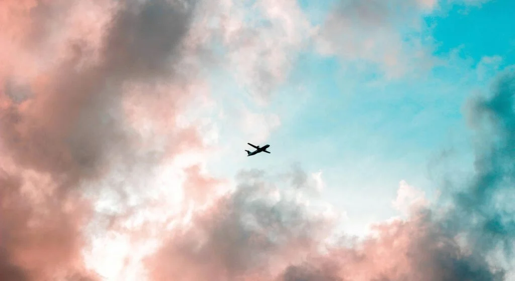 Avión sobrevolando un cielo azul y rosado